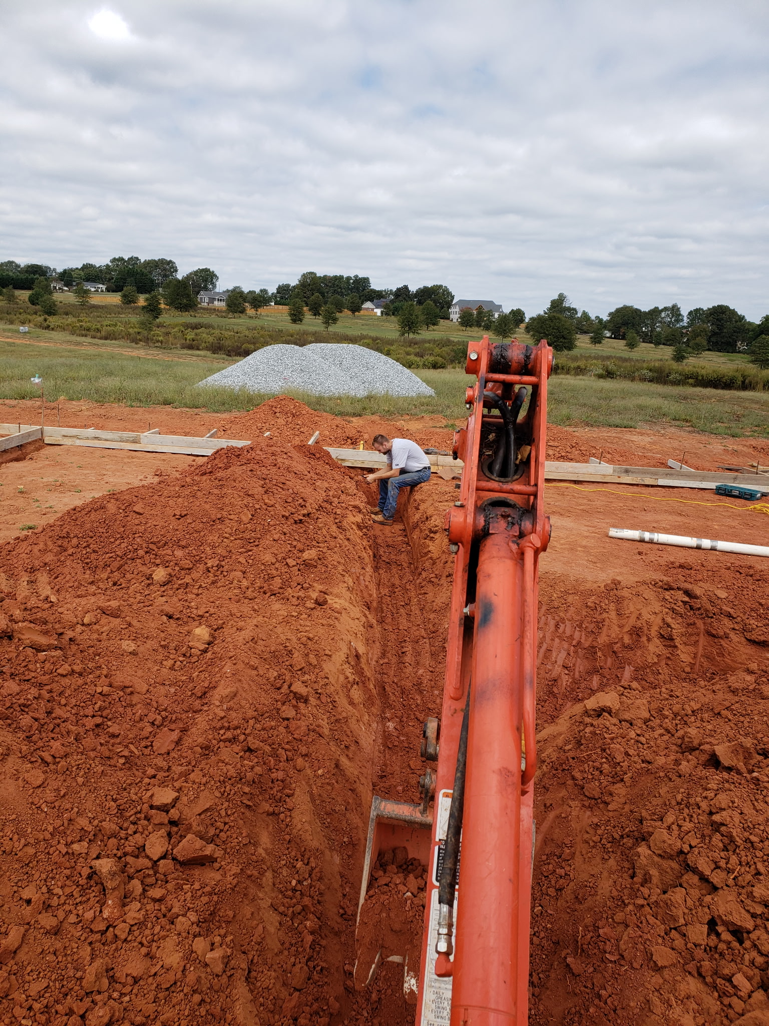 Excavator digging a trench for underground plumbing lines