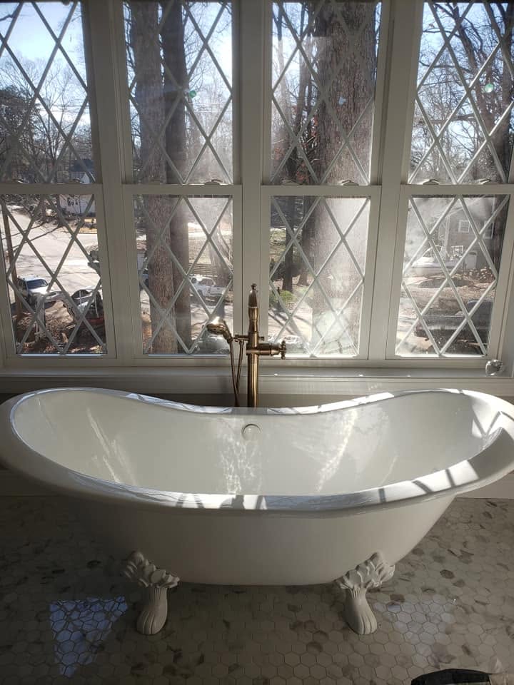 Freestanding clawfoot tub with floor-mounted filler and handheld
