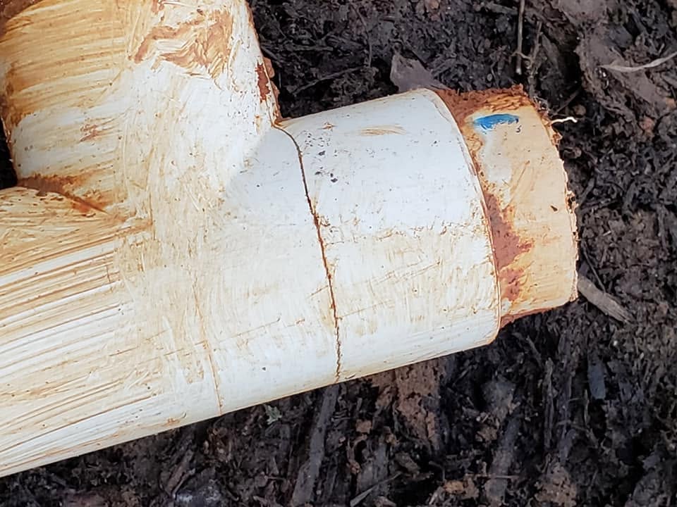 Damaged underground PVC fitting prepared for repair