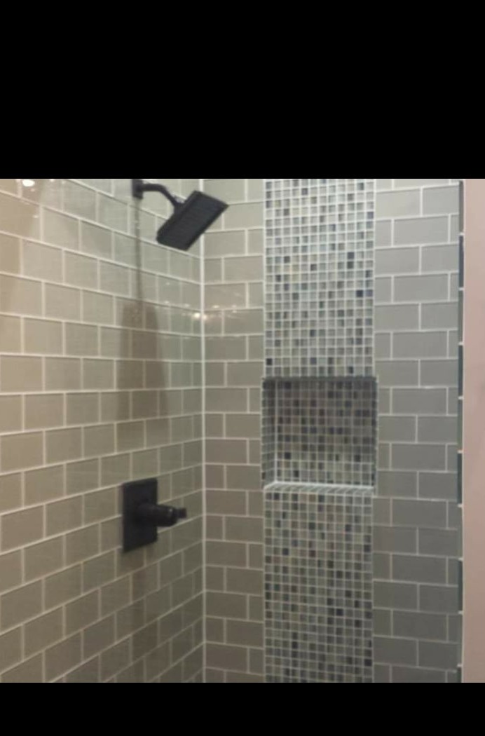 Tiled walk-in shower with matte black rainfall head and mosaic niche